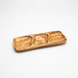 A rectangular wooden serving tray with a wavy, marbled grain pattern, resting on a light brown wooden table.