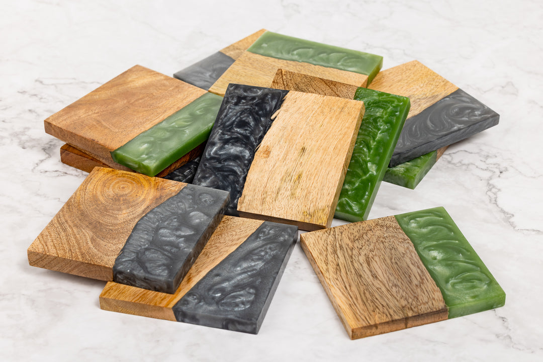 Set of wooden coasters with green and black accents on a marble surface