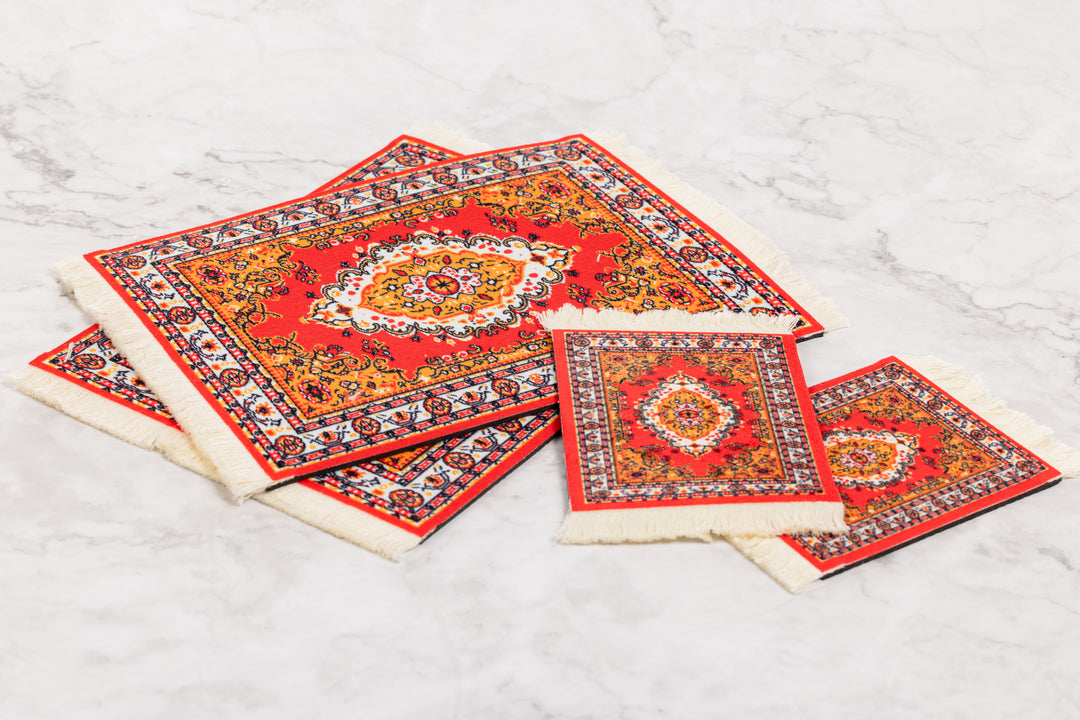 Set of red patterned placemats on a light gray surface