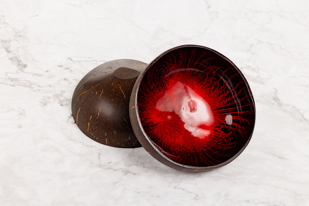 Red glass bowl with dark brown exterior on a white marble surface