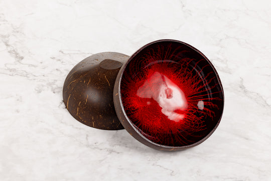 Red glass bowl with dark brown exterior on a white marble surface