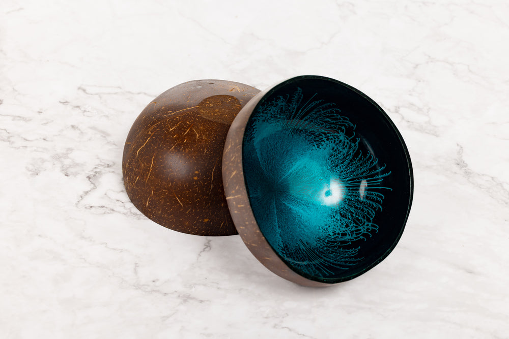 Coconut shell bowl with a blue interior on a marble surface