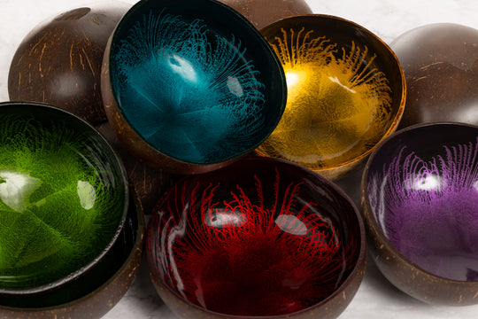 Colorful coconut shell bowls with a textured interior on a white background