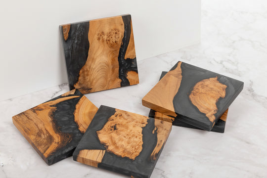 Wooden coasters with black resin on a white surface