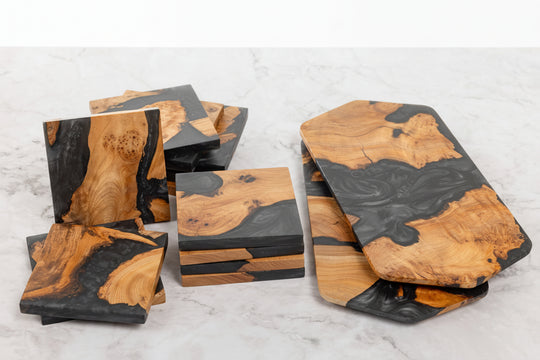 Set of wooden coasters with black accents on a marble surface