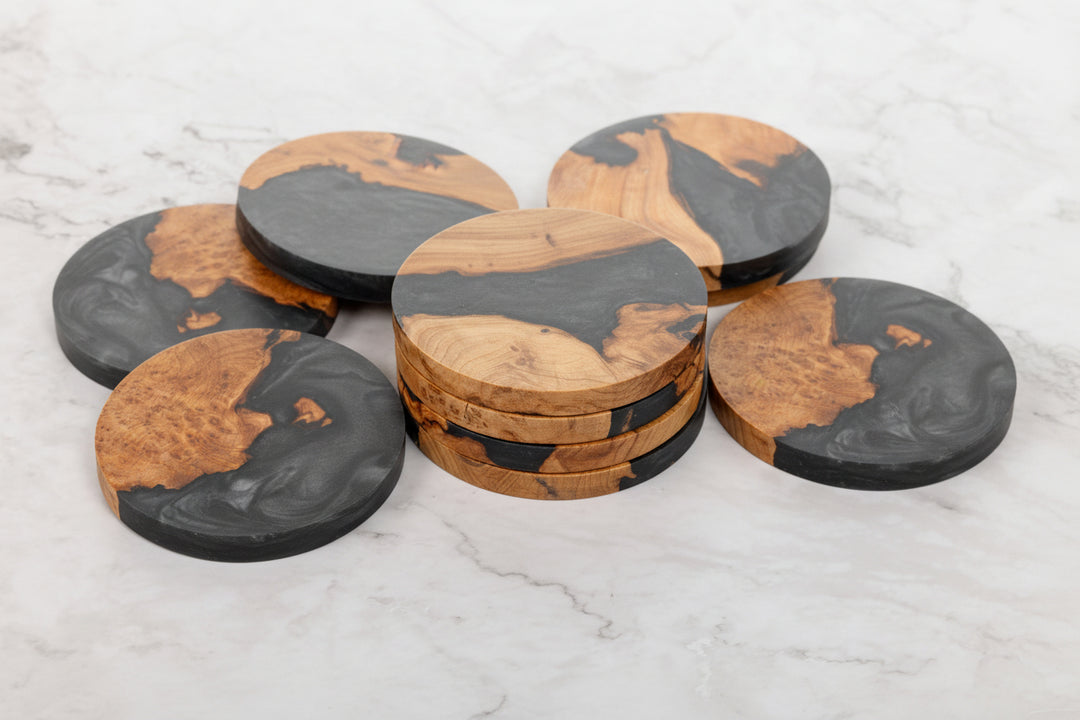 Set of round wooden coasters with black accents on a light gray surface