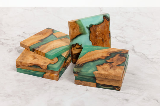 Wooden coasters with green resin on a marble surface
