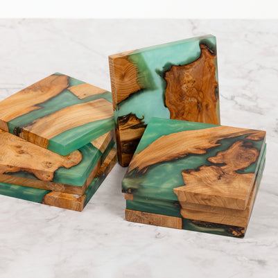 Wooden coasters with green resin on a marble surface