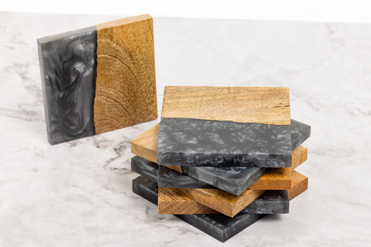 Stack of wooden and stone coasters on a marble surface