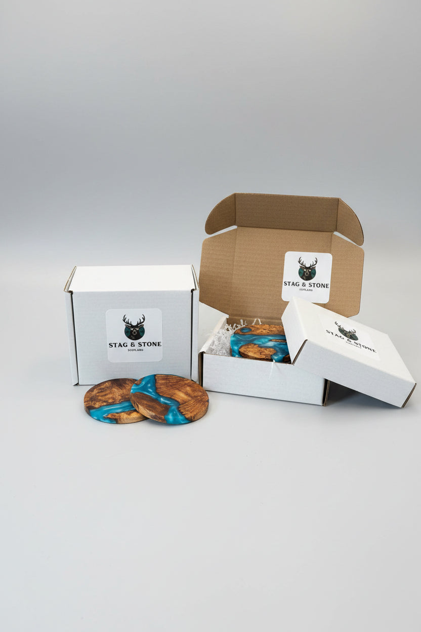 Wooden coasters with blue resin on a wooden surface, with 'Stag & Stone' branded box in the background.