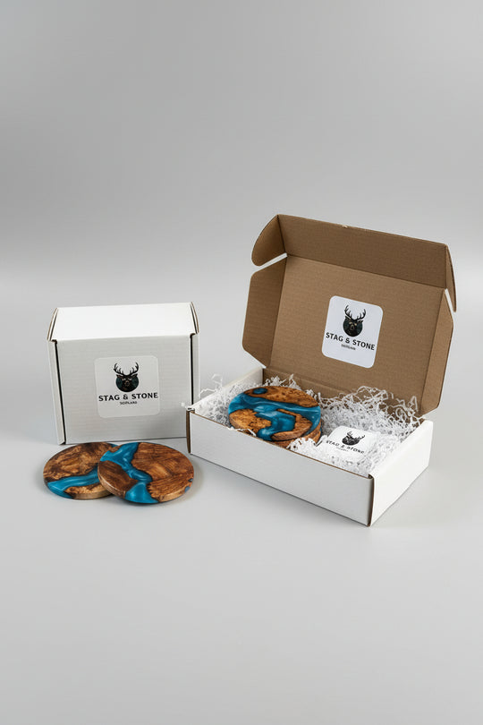 Two boxes, one open and one closed, containing cookies with blue icing on a gray background.