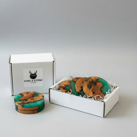 Wooden coasters with green and brown design in a box labeled 'Stag & Stone'.