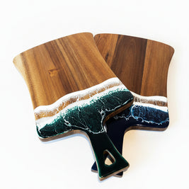Wooden cutting board with a black and white pattern on a wooden surface