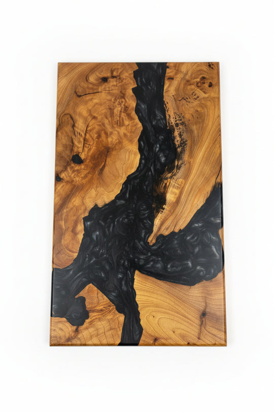 A rectangular live-edge wooden board with a swirling black resin river running through warm brown wood grain, shown against a plain white background.
