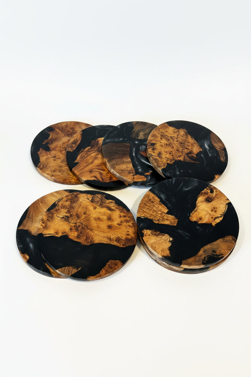 Six oval coasters with a black and natural burl wood grain pattern, arranged on a white background.