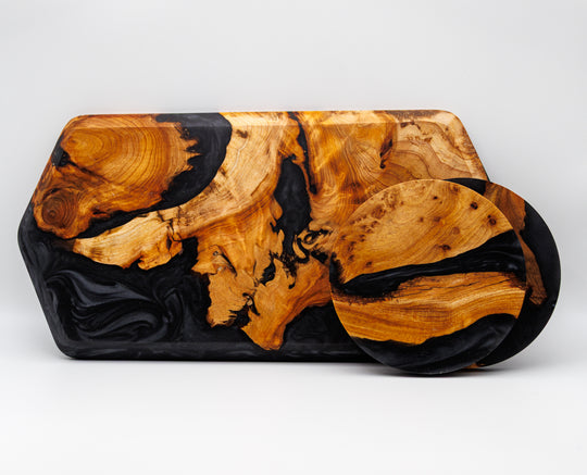 Wooden cutting board with black resin on a white background