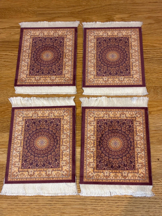 Four patterned rugs with tassels on a wooden surface