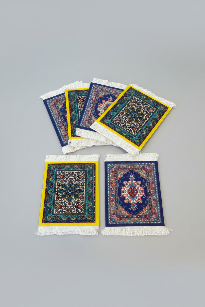 Set of small decorative rugs with intricate patterns on a wooden surface