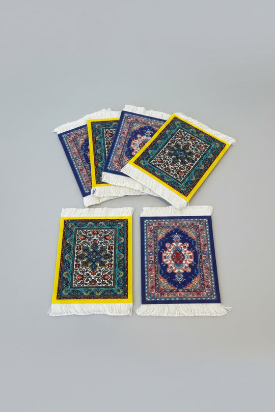 Set of small decorative rugs with intricate patterns on a wooden surface