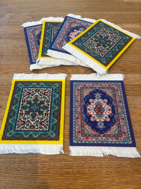 Set of small decorative rugs with intricate patterns on a wooden surface