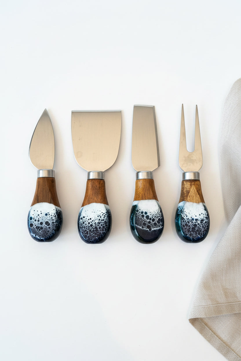 Four cheese knives and a fork with polished steel blades and marbled resin handles in brown, black, and white, arranged on a brown burlap surface.